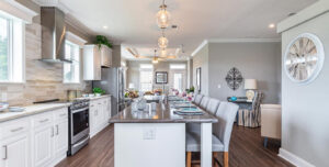 Bright Silver Bay kitchen with white cabinets, stainless steel appliances, a large center island, and adjacent dining area.