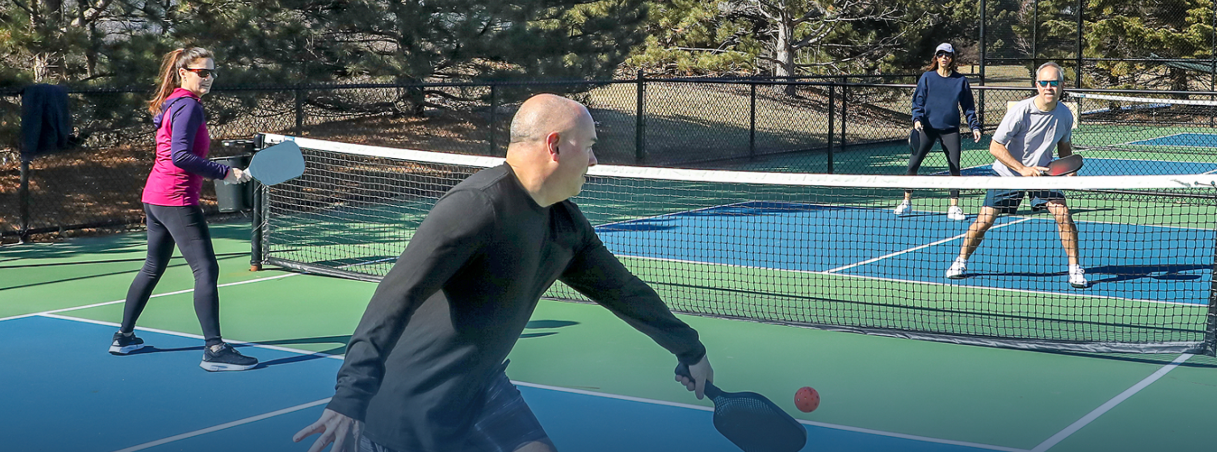 four senior citizens playing pickleball