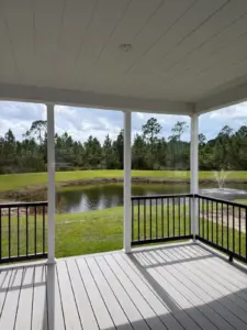 Covered porch at Silver Bay overlooking a pond and wooded landscape.